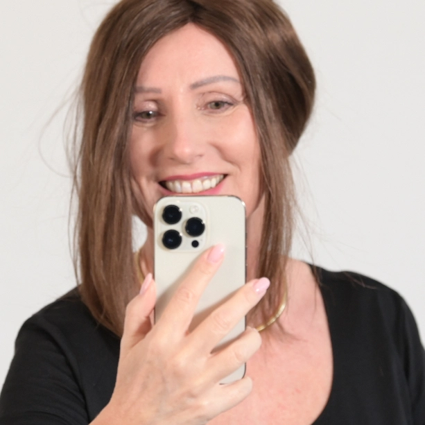 Regina Tschöpe schaut lächelnd auf ihr Smartphone.